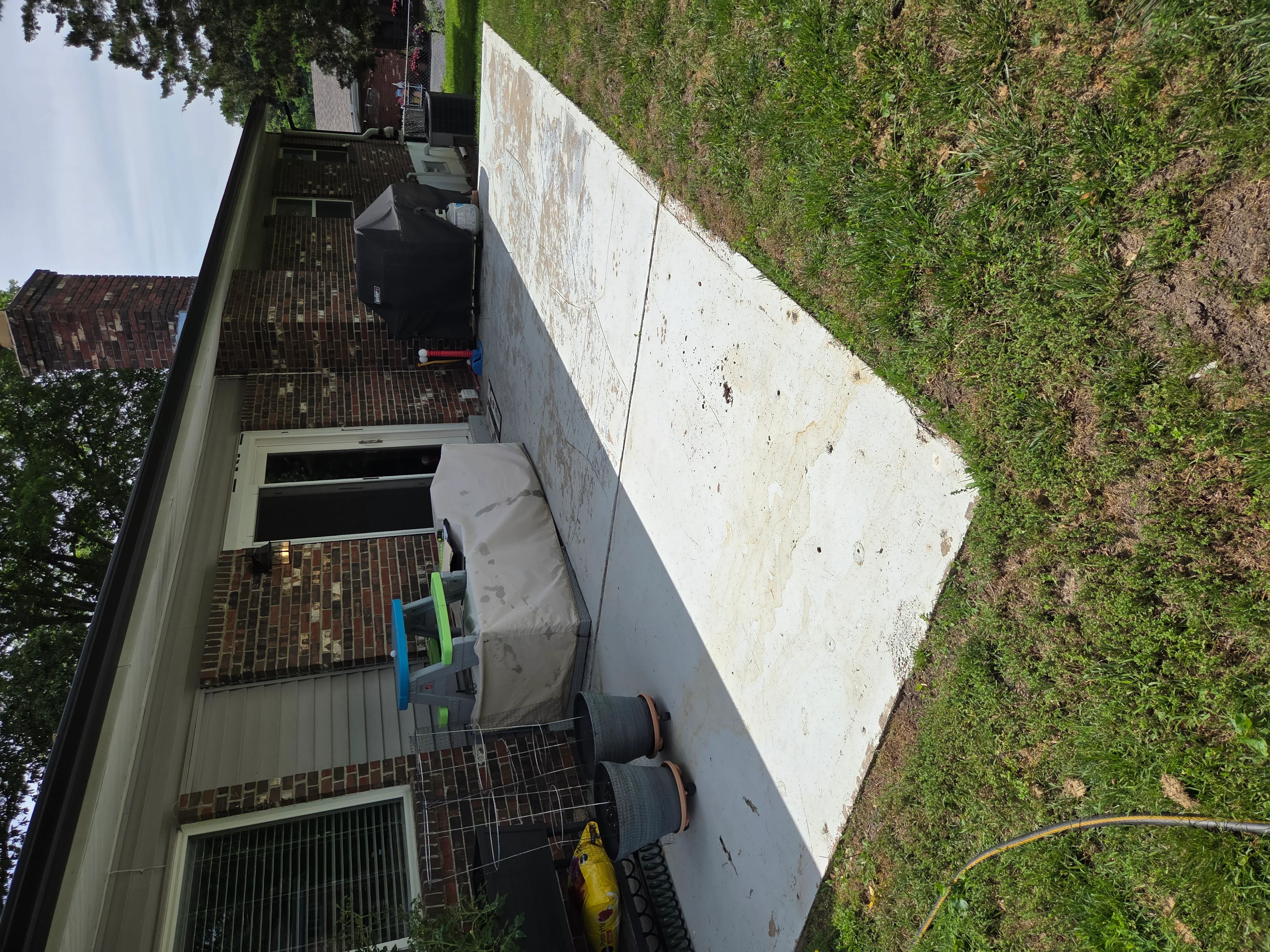 Poured concrete foundation wall with brick veneer exterior and site grading