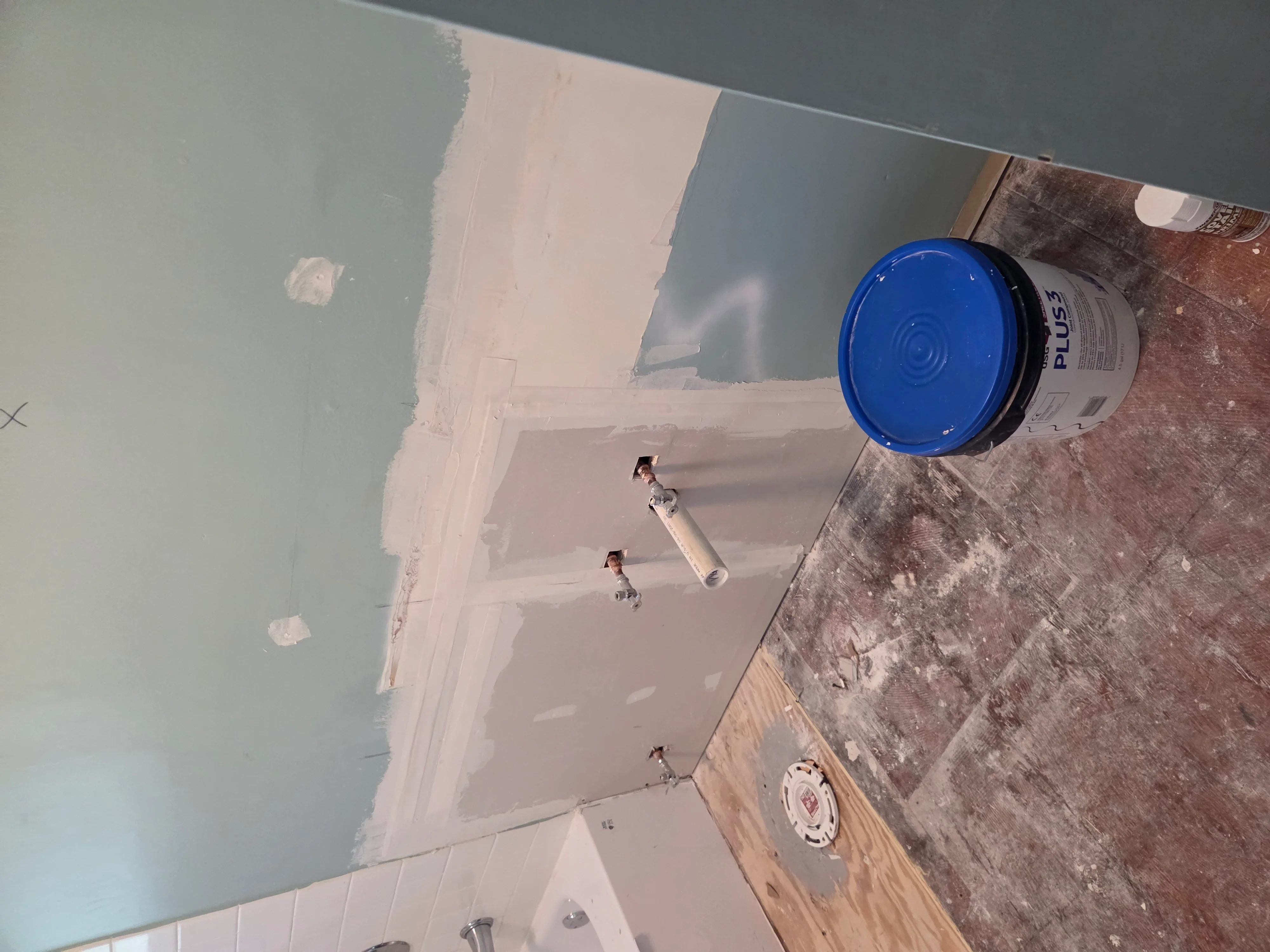 Drywall sheets installed on ceiling and walls with joint compound and finishing supplies