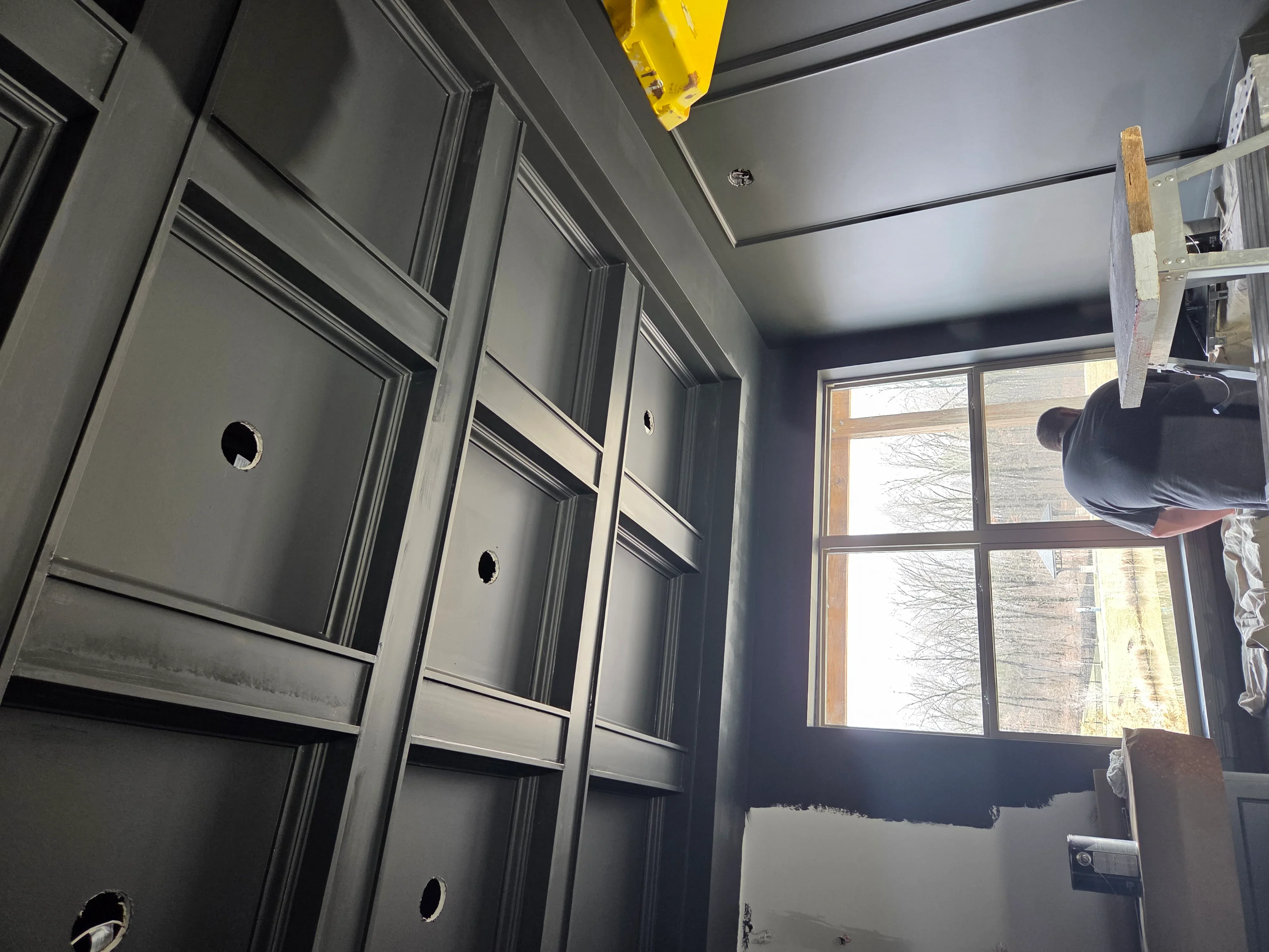 Gray painted drywall walls and ceiling with white trim and hardware installation in progress