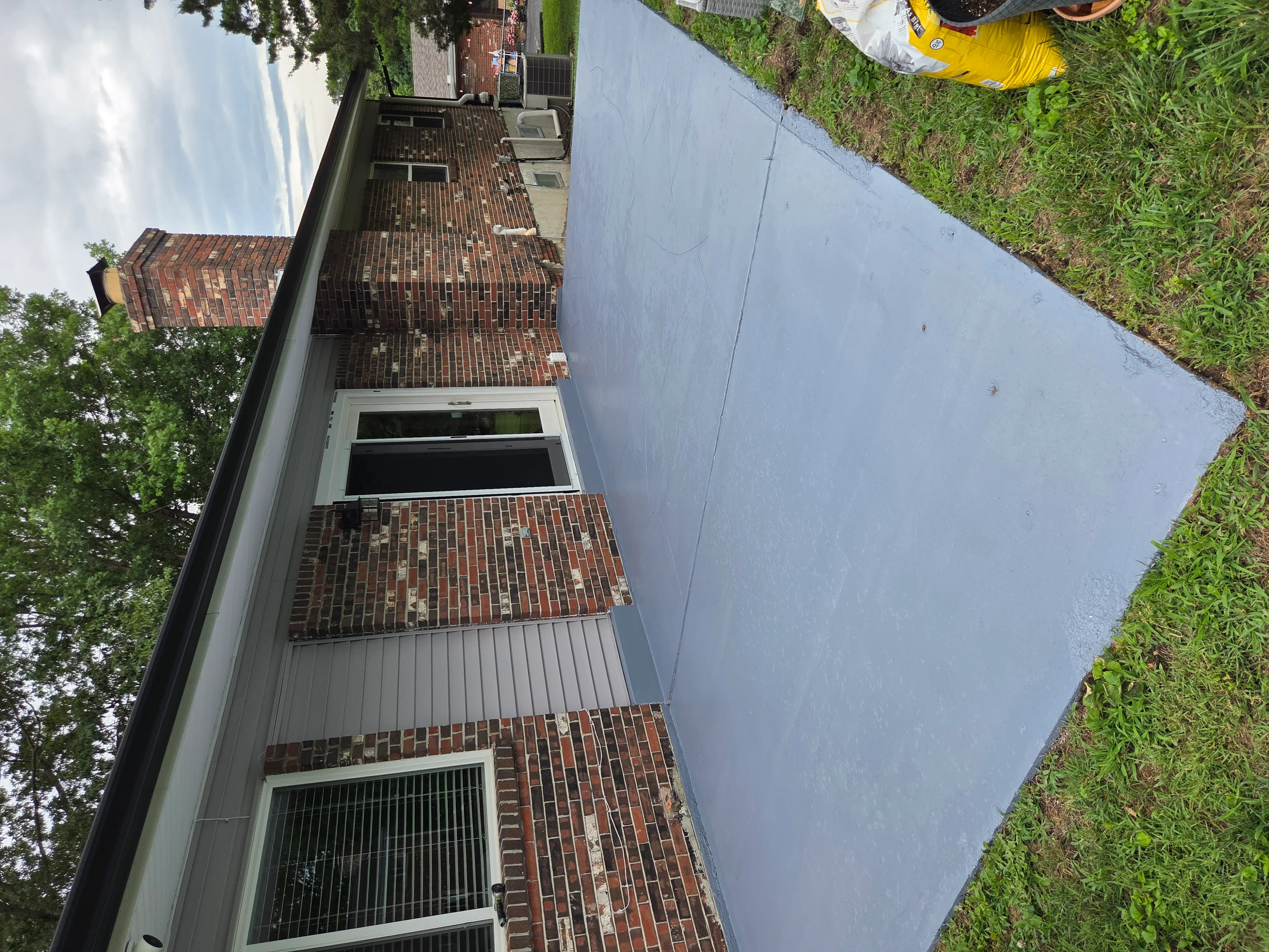 New concrete driveway and brick veneer siding on residential home exterior