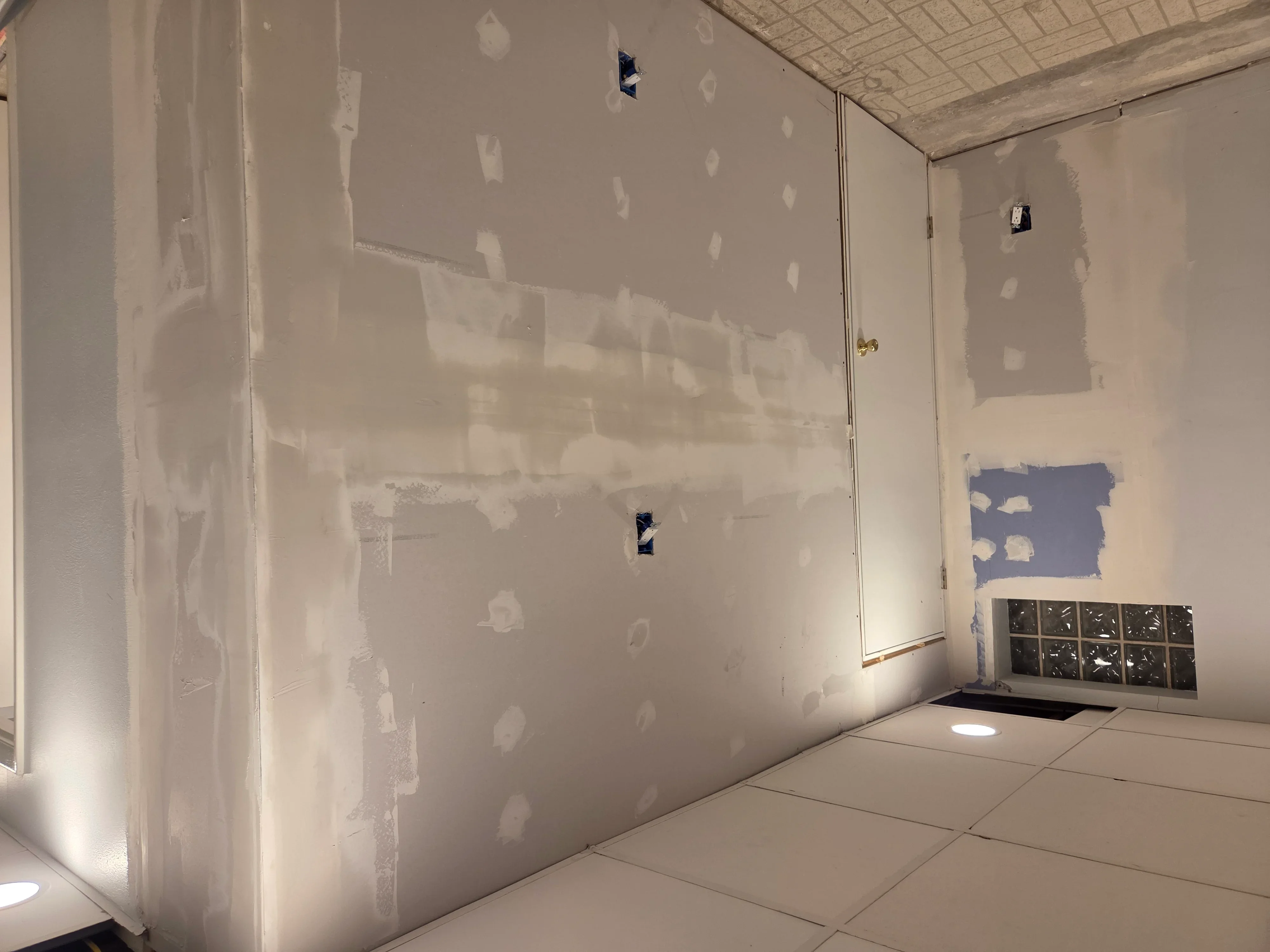 Drywall finishing with taped seams and joint compound on interior walls and ceiling
