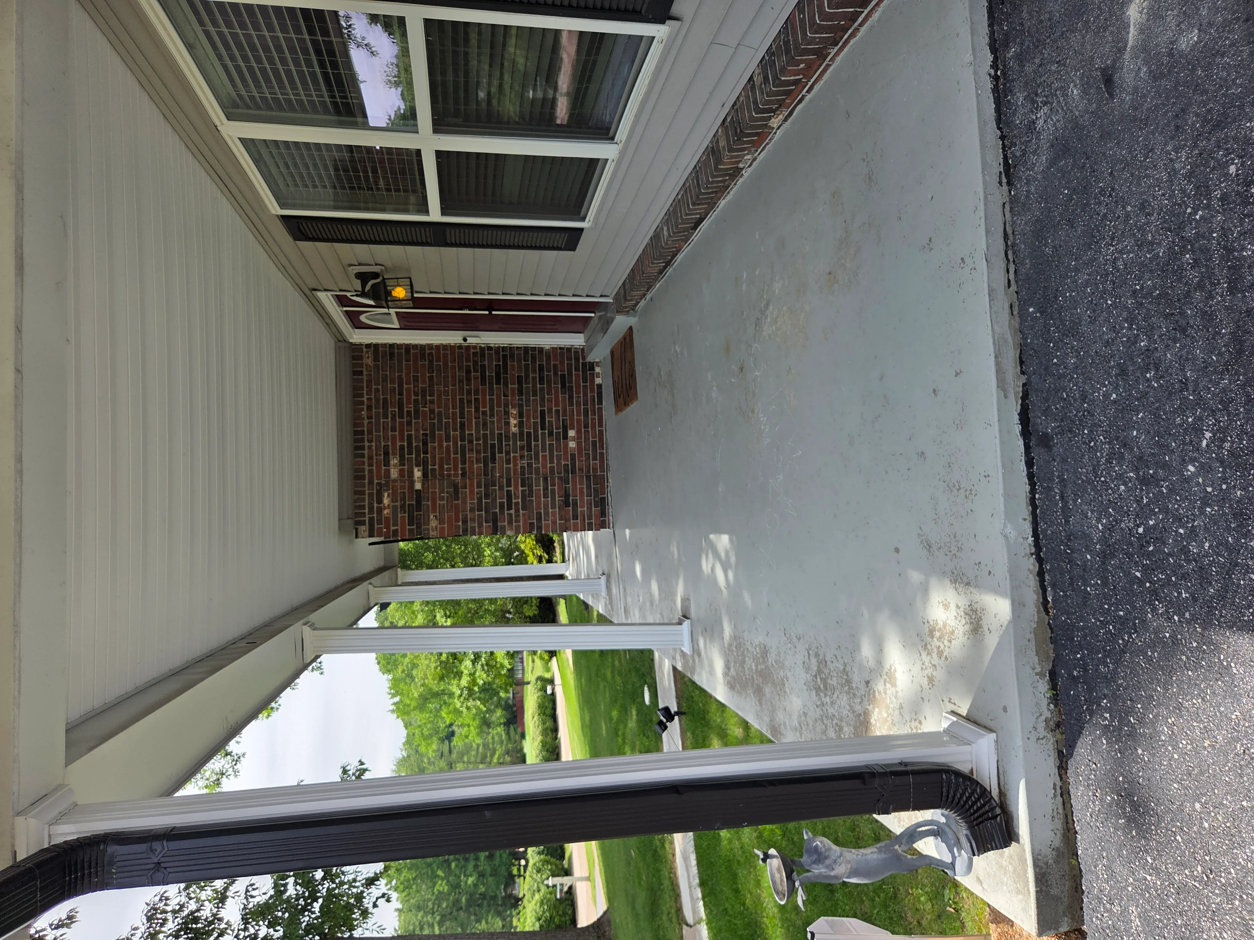 Carport with polycarbonate roof panels and corrugated metal siding attached to brick home