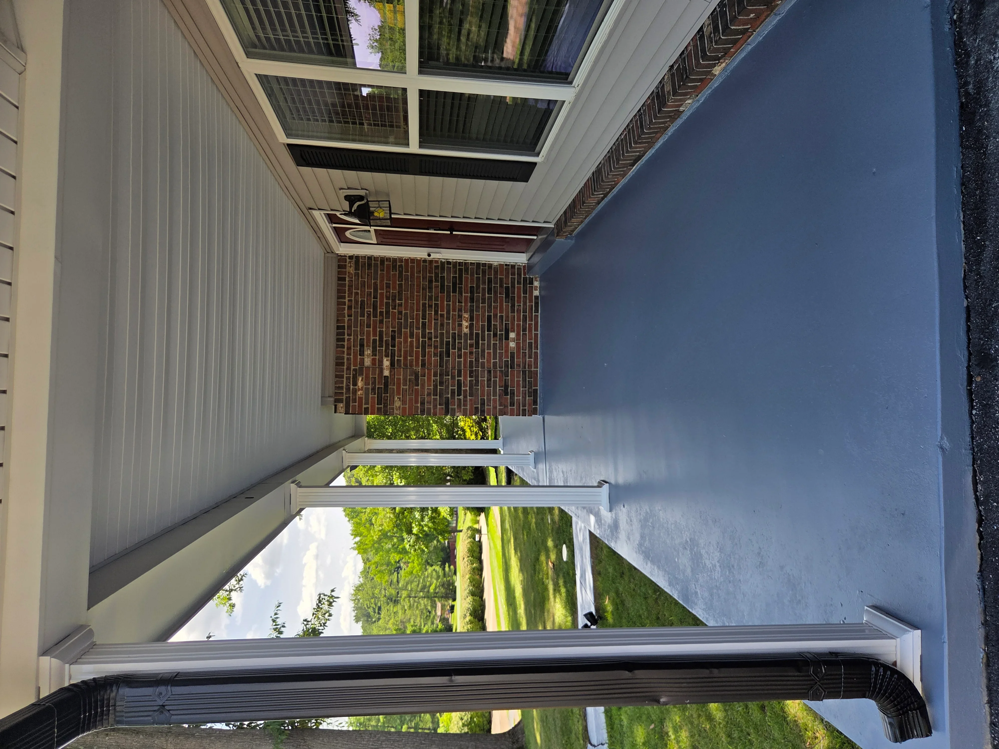 Metal carport with skylights, white frame, and corrugated roof over driveway