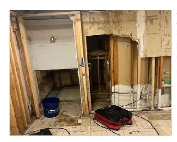 Interior demolition showing exposed framing, removed drywall, and cleared flooring