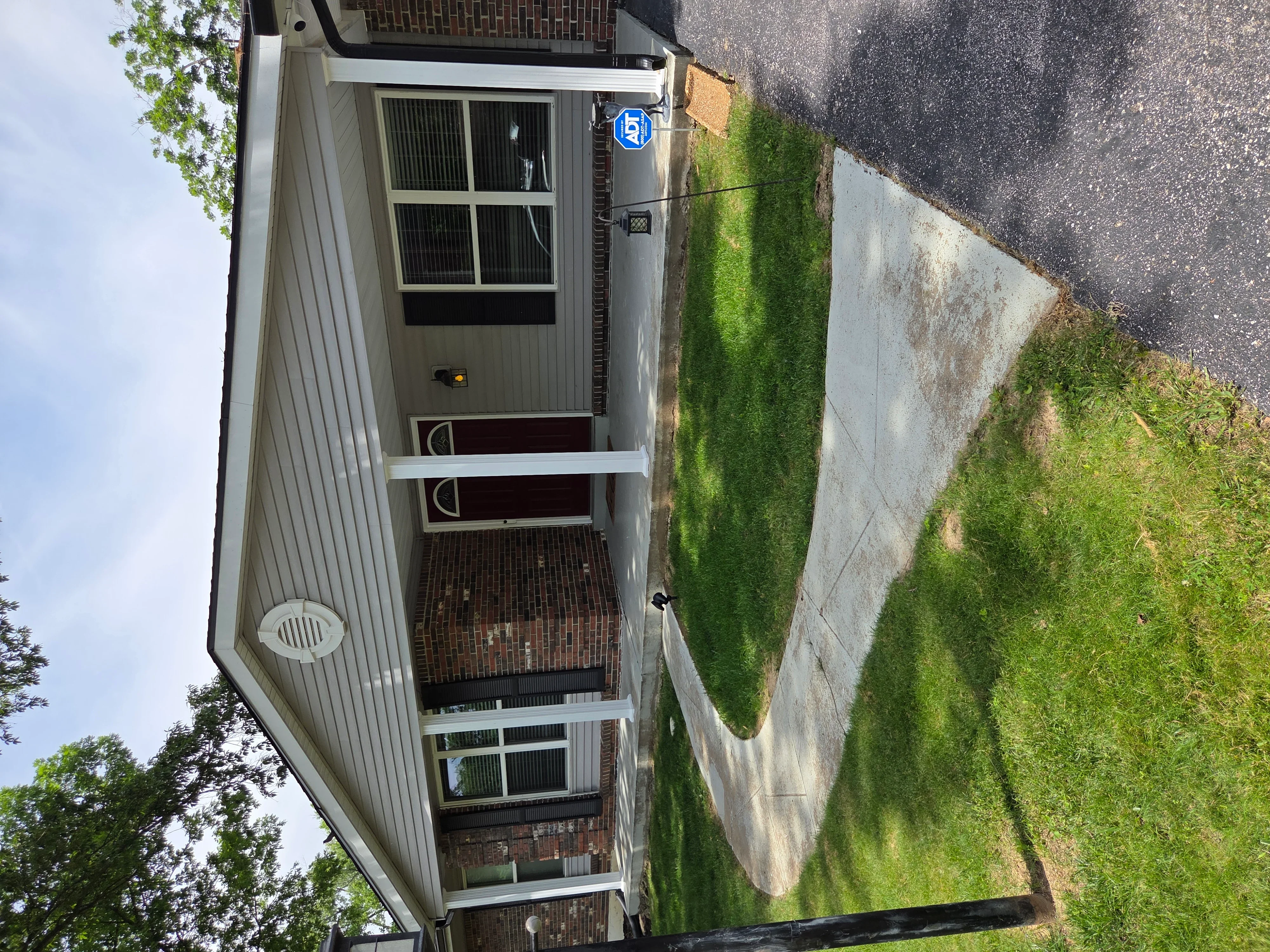 Metal siding, new windows and doors with white trim, concrete foundation work on residential home